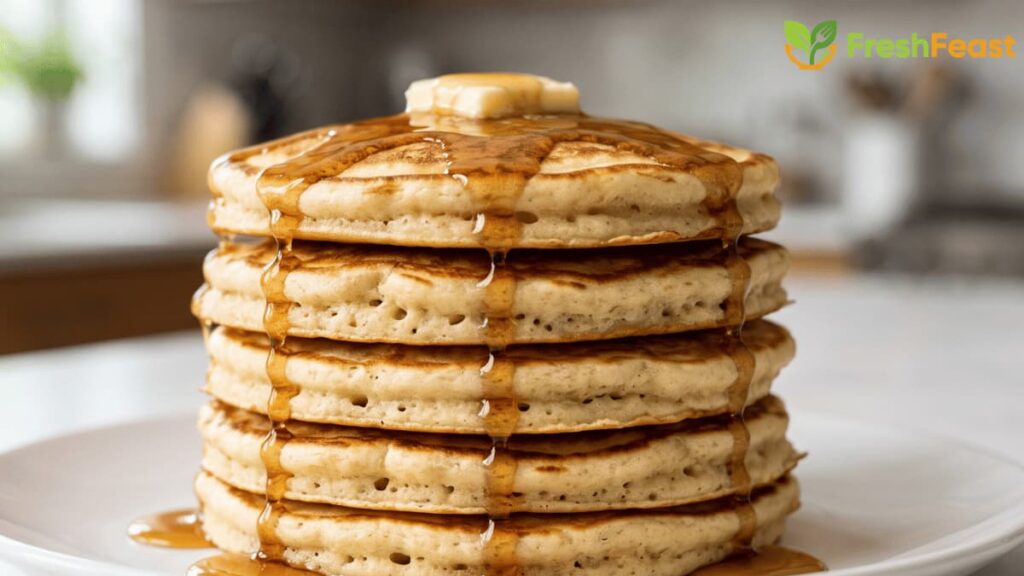 Easy fluffy homemade pancakes stacked on a white plate with melting butter and maple syrup, perfect for a quick breakfast.