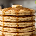 Easy fluffy homemade pancakes stacked on a white plate with melting butter and maple syrup, perfect for a quick breakfast.